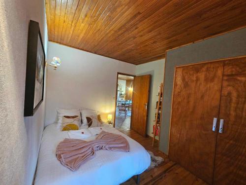 a bedroom with a large bed with a wooden ceiling at Le chalet des Ecureuils - Vue imprenable sur la Dent du Chat in Saint-Jean-de-Chevelu