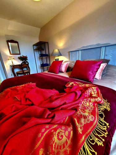 - une couverture rouge au-dessus d'un lit dans l'établissement La Bergeronnette Maison105 m2 3 Chambres, à Bellebrune