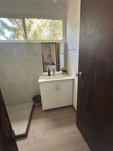 a bathroom with a sink and a mirror and a window at Casa Acuario in Mercedes