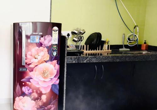 a refrigerator in a kitchen with flowers on it at Sa-Rang! Where Love Blossoms Karjat in Karjat