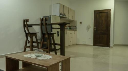 a kitchen with two chairs and a table with a wine glass at Estadía perfecta a tu estilo ! Cerca al Mar in Carepa