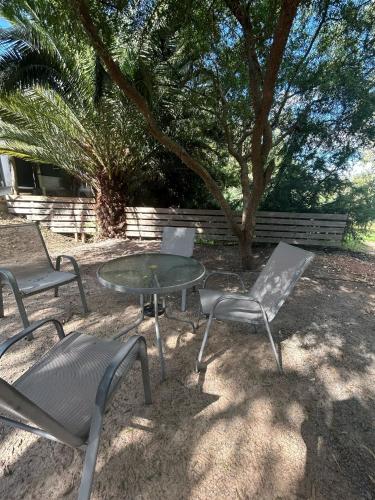 a group of chairs and a table and a tree at Casa Acuario in Mercedes