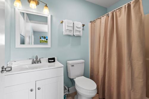 a bathroom with a toilet and a sink and a mirror at Standard Hotel Room - King Bed #2 in Fort Pierce