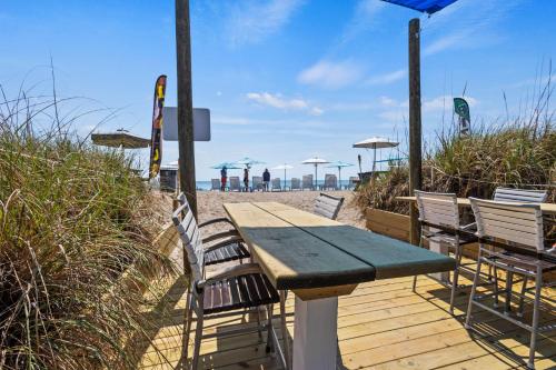 a wooden table and chairs on the beach at Standard Hotel Room - King Bed #2 in Fort Pierce