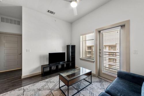 a living room with a couch and a tv at Modern 1BR near TPC Golf in McKinney