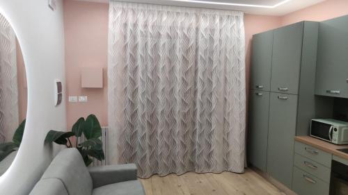 a living room with a couch and a curtain at Albert house in La Pescaia