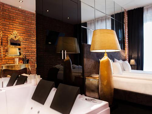 a hotel room with a bed and a lamp at Hotel Betmanowska Main Square Residence Adults Only in Kraków