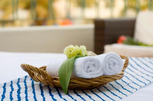 a basket of towels and flowers on a table at Leonardo Club Eilat - All Inclusive in Eilat
