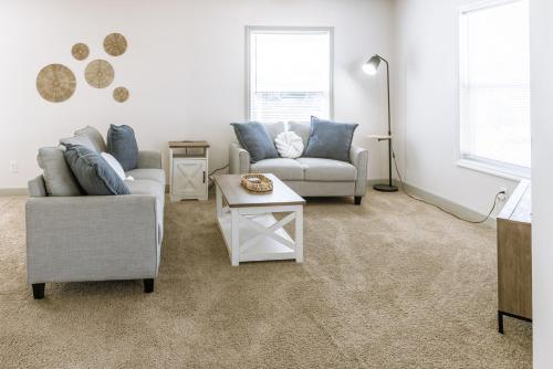 a living room with two couches and a table at Coastal Hubert 3bed Home-Covered Patio, Pet-friendly! in Hubert