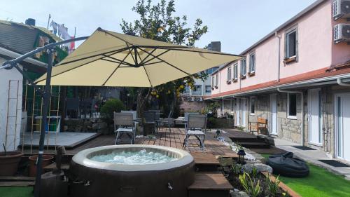 an umbrella on a deck with a hot tub at Ruby Charm Houses in Porto