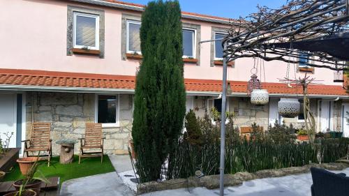 a house with a tall tree in the yard at Ruby Charm Houses in Porto
