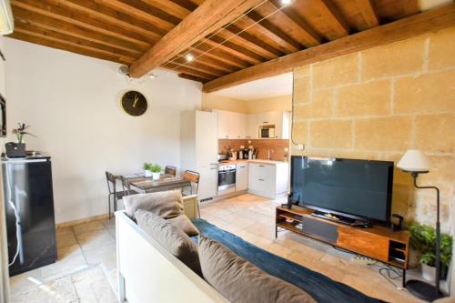 un salon avec un canapé et une télévision à écran plat dans l'établissement Ateliers, Terrasse - Parking - Clim, à Arles