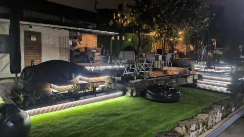 a backyard at night with a lawn and chairs at Ruby Charm Houses in Porto