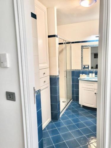 a bathroom with a shower and a blue tile floor at L'Agrumeto in Anacapri