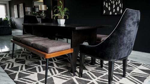 a black table and chair with a bench in a room at Spacious Black Themed Apartment Victoria Island in Lagos