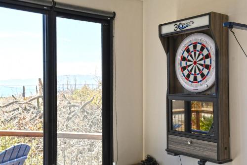 a dart board in a clock next to a window at 20-30 Knots- 5br4ba Game Night Villa Hot Tub in El Sargento