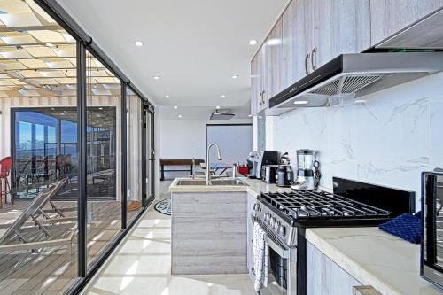 a kitchen with a stove top oven next to a balcony at 20-30 Knots- 5br4ba Game Night Villa Hot Tub in El Sargento
