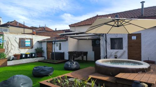 a backyard with a hot tub and an umbrella at Ruby Charm Houses in Porto