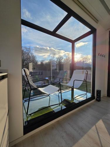 Cette chambre offre une vue sur un balcon doté d'une fenêtre en verre. dans l'établissement chic evasion, à Chambeire