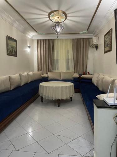 a living room with a blue couch and a table at Bel appartement quartier Bourgogne in Casablanca