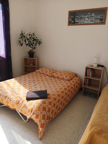 - une chambre avec un lit et une couette en orange dans l'établissement La maisonnette, à Cléry-Saint-André