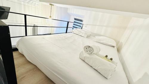un lit avec des draps blancs et des serviettes dessus dans l'établissement Croisette Studio, Palais des Festivals and Beach, à Cannes