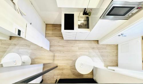 - un escalier dans une petite maison dotée de murs blancs et de parquet dans l'établissement Croisette Studio, Palais des Festivals and Beach, à Cannes