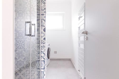 une salle de bain avec douche aux carreaux bleus et blancs dans l'établissement Le Bergamote Stationnement gratuit sur place, à Nancy