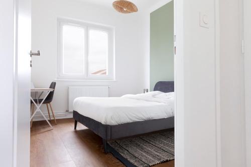 une chambre avec un lit, un bureau et une fenêtre dans l'établissement Le Bergamote Stationnement gratuit sur place, à Nancy