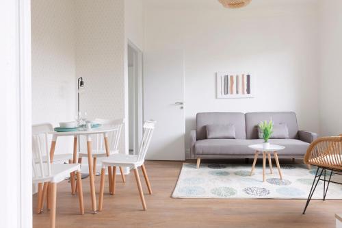 un salon avec un canapé, une table et des chaises dans l'établissement Le Bergamote Stationnement gratuit sur place, à Nancy