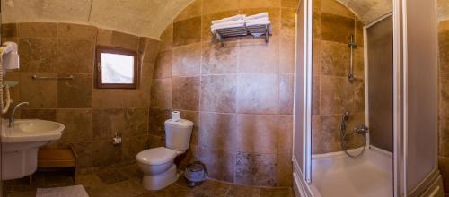a bathroom with a shower and a toilet and a sink at Kirkit Hotel in Avanos