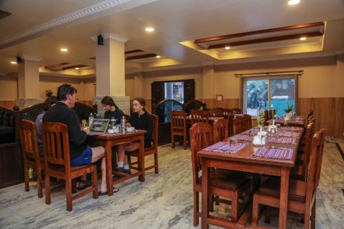 a group of people sitting at tables in a restaurant at Pokhara Choice Inn in Pokhara