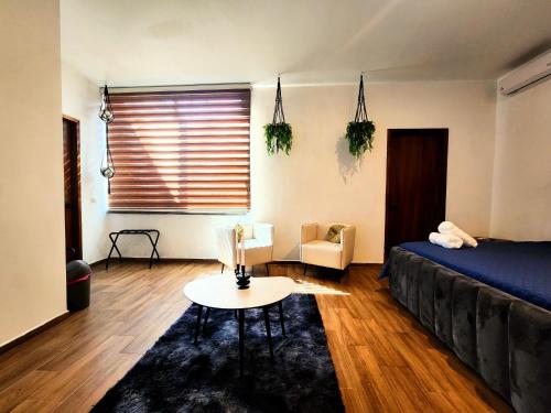 a bedroom with a bed and a table and a chair at Suite 3 en Tlaquepaque centro in Guadalajara