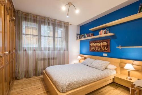 a blue bedroom with a bed and a blue wall at Apartamento La Benasquita in Benasque