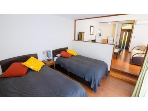 una camera da letto con due letti e uno specchio di Le Nessa Akazawa - Vacation STAY 16382v a Futo