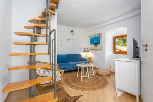 a spiral staircase in a living room with a blue couch at Villa Marak in Vrbnik