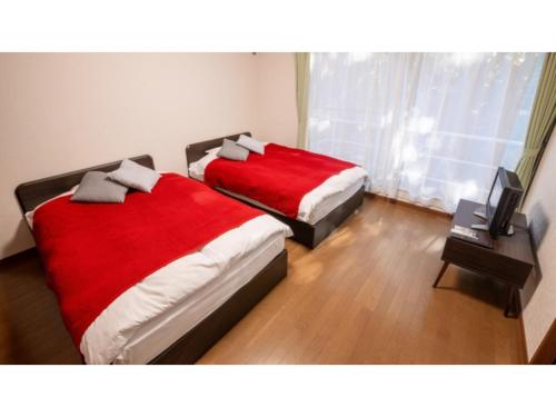 two beds in a bedroom with red blankets at Le Nessa Akazawa - Vacation STAY 16387v in Futo