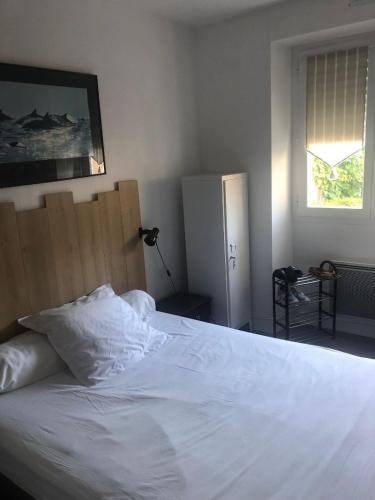 une chambre avec un lit blanc et une fenêtre dans l'établissement Les pieds dans l'eau, à Saint-Malo