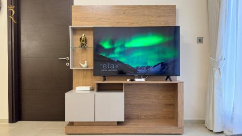 a television on a wooden stand in a room at 1BR Al Reem - Chic Comfort Cove Retreat in Abu Dhabi
