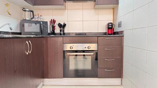 a kitchen with a stove and a microwave at 1BR Al Reem - Chic Comfort Cove Retreat in Abu Dhabi