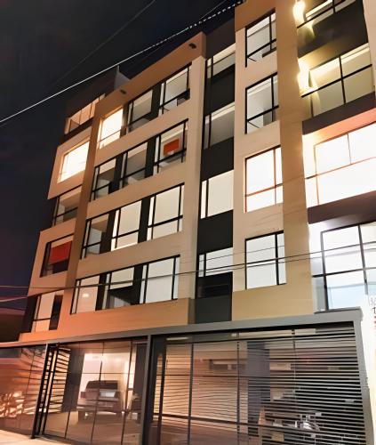 an apartment building with its facade lit up at night at Domus Suites Chia in Chía
