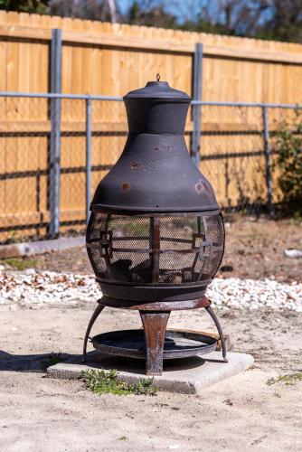 a black vase sitting on a stand on the ground at Coastal Hubert 3bed Home-Covered Patio, Pet-friendly! in Hubert