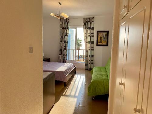 a bedroom with a bed and a green couch at Sea Front Villa Ekaterina in Paphos City