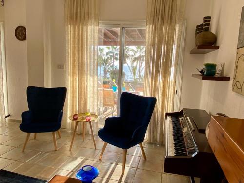 a living room with two chairs and a keyboard at Sea Front Villa Ekaterina in Paphos City