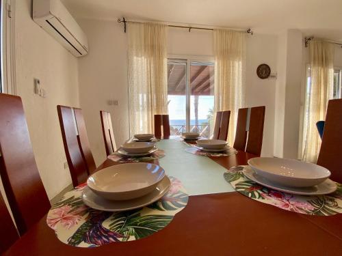 a dining room with a table with plates on it at Sea Front Villa Ekaterina in Paphos City