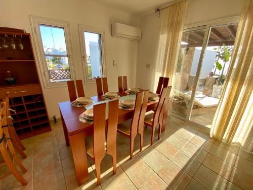 a dining room with a wooden table and chairs at Sea Front Villa Ekaterina in Paphos City