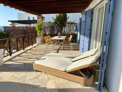 a porch with a bed and a table and chairs at Sea Front Villa Ekaterina in Paphos City