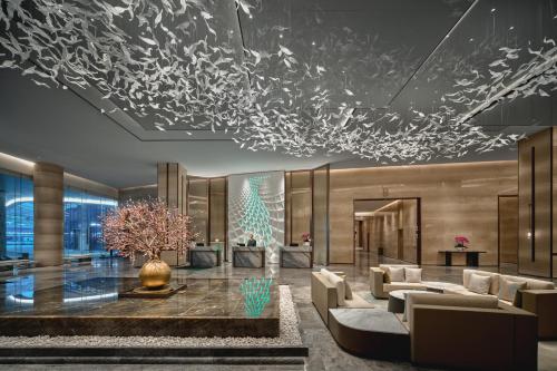 a lobby with couches and a christmas tree at Holiday Inn Wuhan Tianhe Airport by IHG in Wuhan