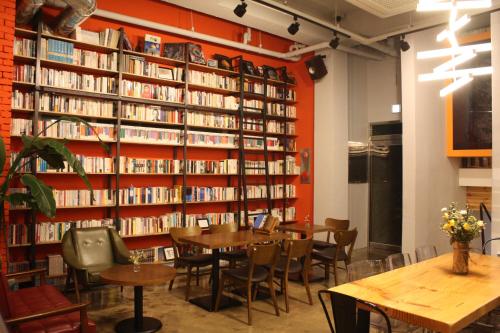 a library with a table and chairs and books at Andong Poong-gyung HOSTEL n LIBRARY in Andong