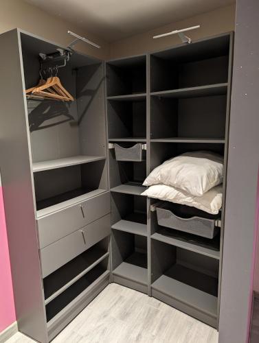 a walk in closet with black shelves and a bed at La Maison Villageoise in Baix